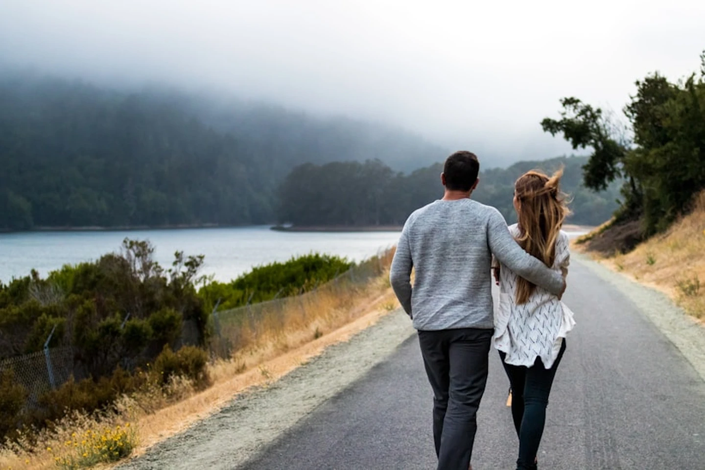 Couple walking down the street next to the lake